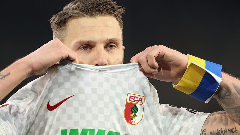 Augsburgs Jeffrey Gouweleeuw zieht sein Trikot vors Gesicht.