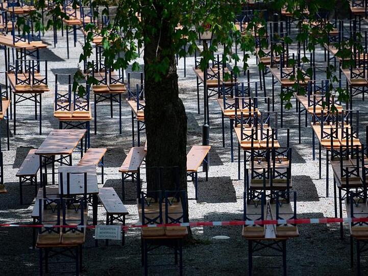 Menschenleer zeigt sich ein Biergarten mit gestapelten Bänken und Tischen im Münchner Westpark. Foto: Sven Hoppe/dpa/Archivbild