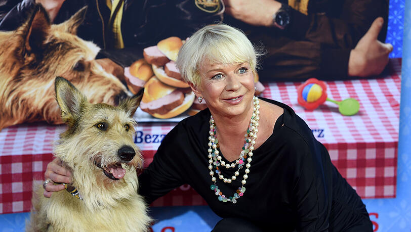 Die Autorin Rita Falk und der Filmhund Joker bei der Premiere des Films "Leberkäsjunkie" im Mathäser Filmpalast auf dem Roten Teppich.