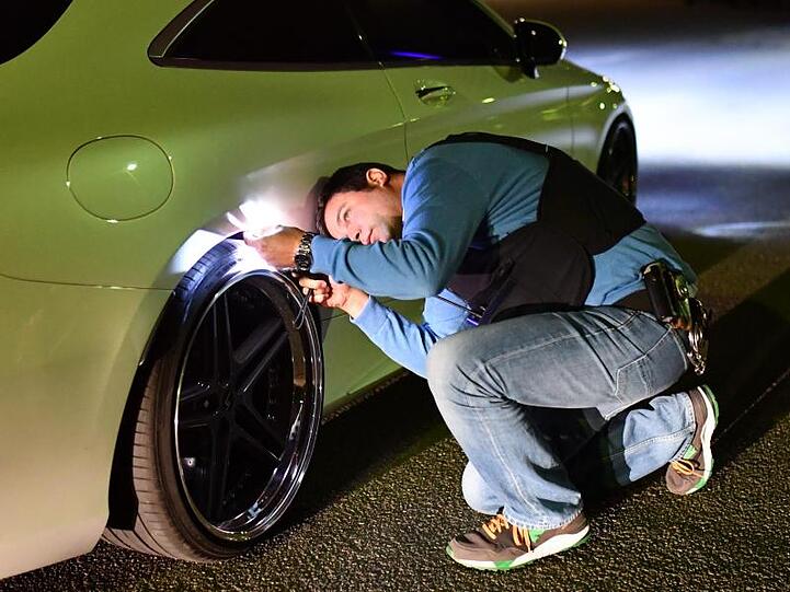 Ein Polizist kontrolliert in Mannheim das Auto eines mutmaßlichen Autoposers. F.