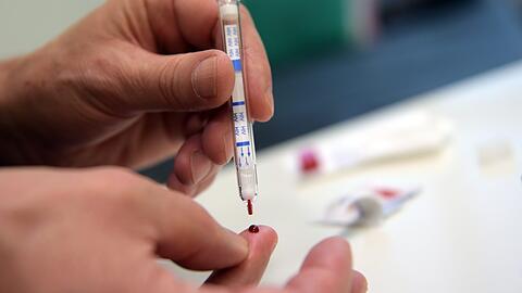 Ein junger Mann führt einen HIV-Heimtest durch.