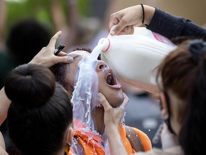 Wegen Tränengas-Einsatz wird das Auge einer Demonstrantin mit Milch ausgespült.