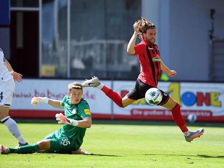 Der Freiburger Lucas Höler (r) erzielt das 3:0 gegen Schalke-Torwart Alexander Nübel (M), der das Nachsehen hat.