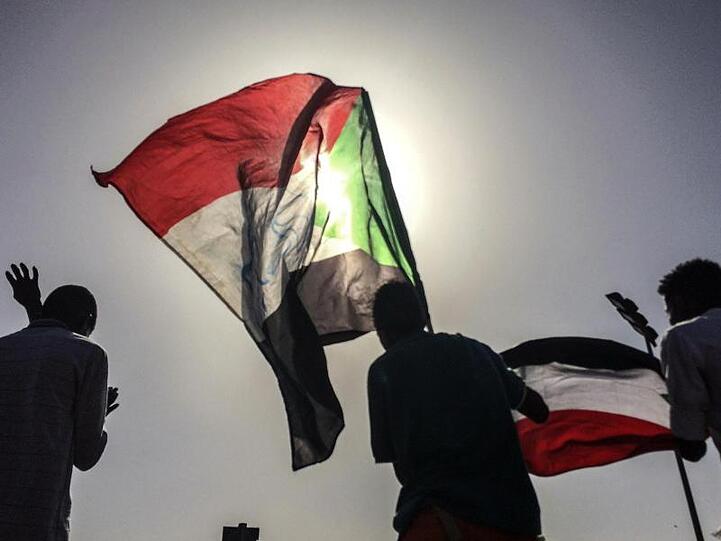 Sudanesische Demonstranten schwenken bei einer Kundgebung in Khartum Nationalflaggen.