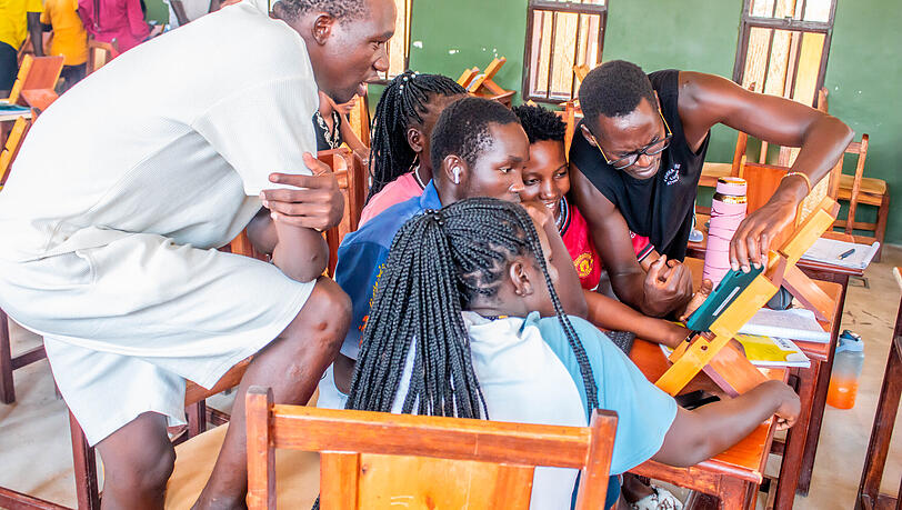 Eine Gruppe schaut in Turkana auf ein Smartphone. Mittlerweile sind die Geräte so vielseitig, dass nicht mehr zwingend ein Laptop für digitale Arbeit notwendig ist. Eine Gruppe schaut in Turkana auf ein Smartphone. Mittlerweile sind die Geräte so vielseitig, dass nicht mehr zwingend ein Laptop für digitale Arbeit notwendig ist.