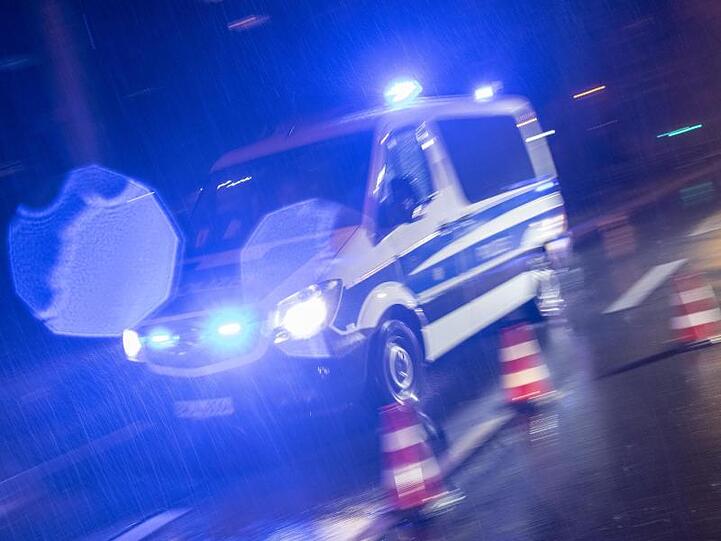 Ein Polizeifahrzeug fährt mit Blaulicht durch den Regen. Foto: Patrick Seeger/dpa/Archivbild