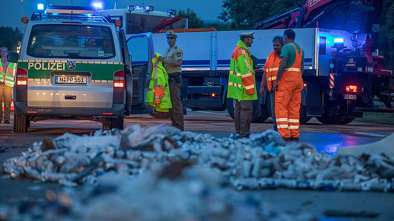 Die A9 ist ein einziges Schlachtfeld: Unzählige Bierdosen liegen nach dem Unfall auf der Fahrbahn verteilt. Beide Lkw-Fahrer kamen mit schwersten Verletzungen ins Krankenhaus.