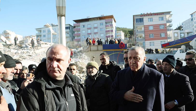 Der türkische Präsident Recep Tayyip Erdogan (r) im zerstörten Stadtzentrum von Kahramanmaras.