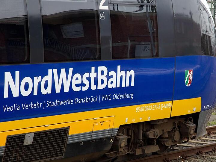 Ein Triebwagen der NordWestBahn steht auf dem Hauptbahnhof in Münster vor einer Lok der Deutschen Bahn.