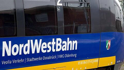 Ein Triebwagen der NordWestBahn steht auf dem Hauptbahnhof in Münster vor einer Lok der Deutschen Bahn.