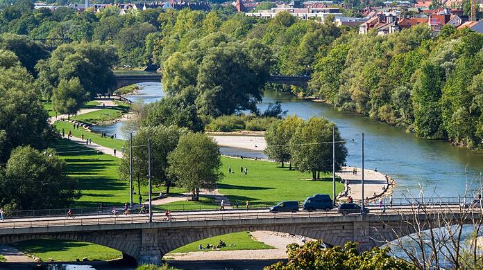 An der Isar entspannen viele Münchner. Trotzdem ist eine Uferseite von Autos geprägt.