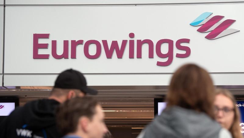 Fluggäste warten an einem Check In-Schalter von Eurowings. Fluggäste warten an einem Check In-Schalter von Eurowings.