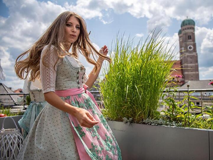 Cathy Hummels, Influencerin, steht im Dirndl vor der Münchener Frauenkirche auf einem Dachgarten. Foto: Lino Mirgeler