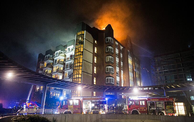 Aus den oberen Stockwerken eines Bochumer Krankenhauses schlagen hohe Flammen - 165 Feuerwehrleute bekämpfen das Feuer.