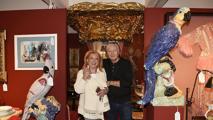 Auktionator Holger Hampel mit seiner Frau Barbara zwischen Papagei-Skulpturen aus Nymphenburger Porzellan (rechts: 3000 – 4000 Euro). Auktionator Holger Hampel mit seiner Frau Barbara zwischen Papagei-Skulpturen aus Nymphenburger Porzellan (rechts: 3000 – 4000 Euro).