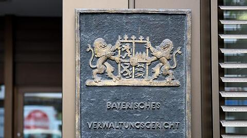 Ein Schild hängt am Eingang am Verwaltungsgericht München. Foto: Tobias Hase/Archivbild