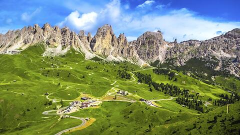 Blick aus der Luft auf den malerischen Gardena Pass/Gr&ouml;dner Pass, umrahmt von den Dolomitengipfeln. Das zieht die Touristen an &ndash; auch die motorisierten.
