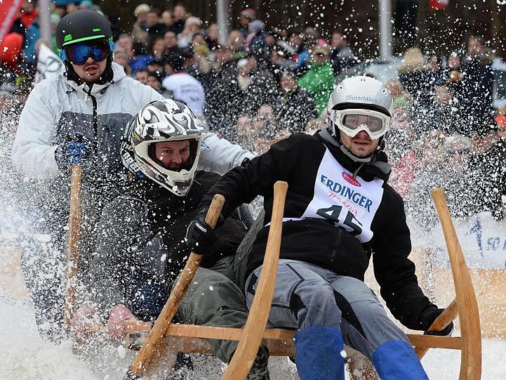 Teilnehmer des traditionellen Hornschlittenrennes fahren die Piste hinab. Foto: Angelika Warmuth