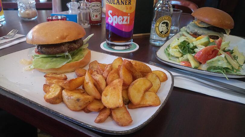 Der Avocado-Burger mit Wedges. Im Hintergrund türmt sich der gigantische Schulz-Burger auf.