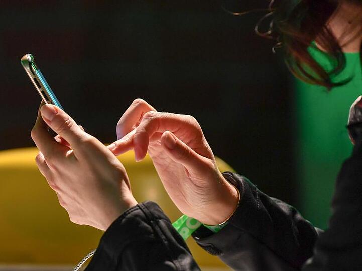 Eine Frau tippt auf ihrem Smartphone. Foto: Jens Kalaene/Archivbild