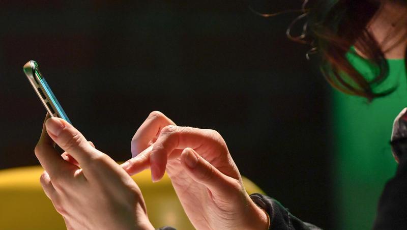 Eine Frau tippt auf ihrem Smartphone. Foto: Jens Kalaene/Archivbild