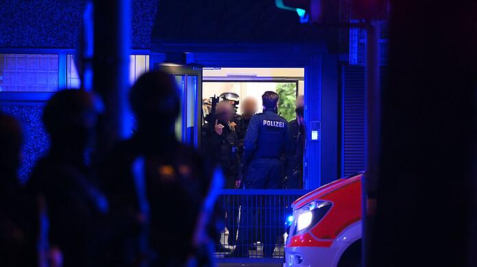 Polizisten stehen in einem Gebäude. Die Polizei spricht von einer Großlage.