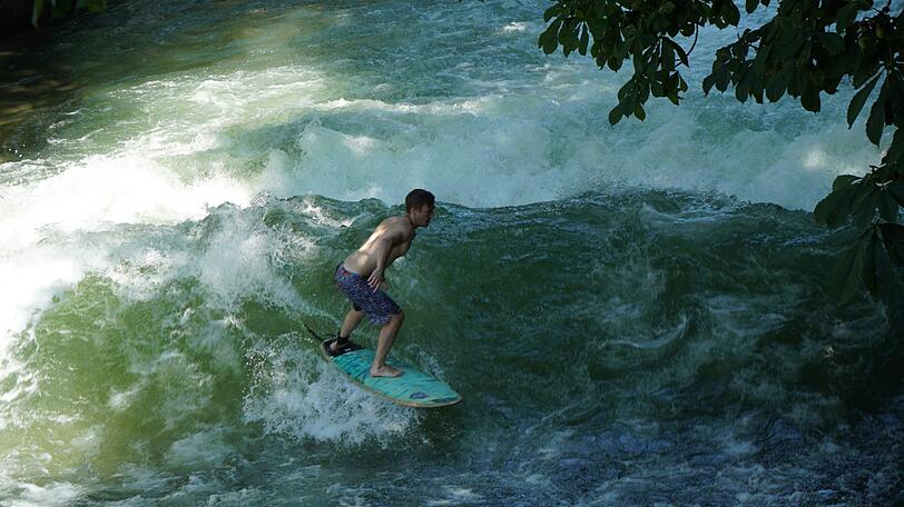 Weltberühmter Hotspot - wer nach München kommt, muss einen kurzen Stopp bei den Eisbach-Surfern einlegen.