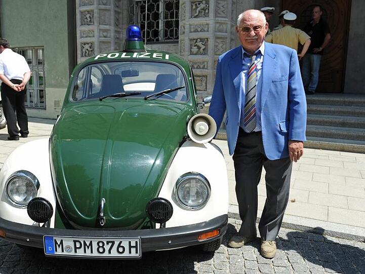Schauspieler Rolf Schimpf steht neben einem alten VW-Käfer-Polizeiauto. Foto: Andreas Gebert/dpa/Archivbild