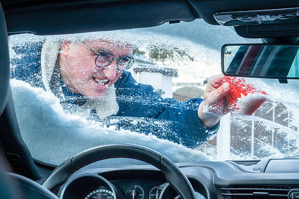Ein Autofahrer macht seinen Wagen im Winter bereit, um sicher in den Verkehr zu starten. Ein Autofahrer macht seinen Wagen im Winter bereit, um sicher in den Verkehr zu starten.
