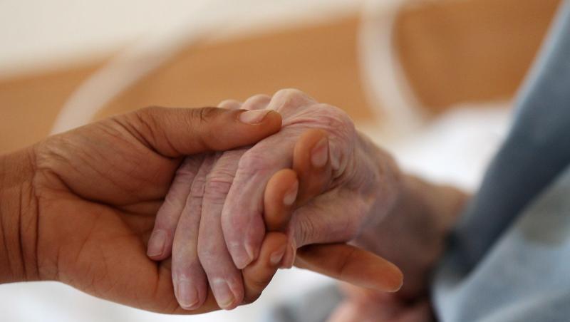 Eine Pflegerin hält im Altenheim die Hand einer Bewohnerin. Foto: Oliver Berg/Archiv Eine Pflegerin hält im Altenheim die Hand einer Bewohnerin. Foto: Oliver Berg/Archiv