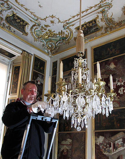 Gürtler Josef Sckell bei der Reinigung der nachgedunkelten Metalloberflächen.