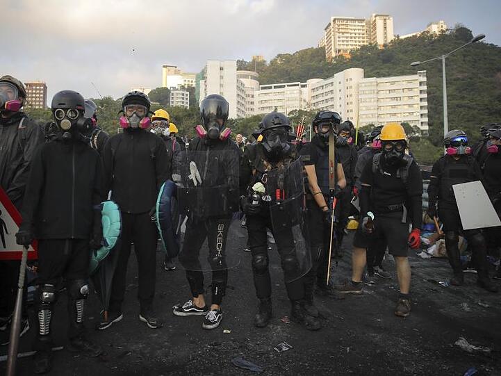 In Kampfmontur: Bewaffnete Studenten mit selbstgebauten Atemmasken vor eines Universität in Hongkong.