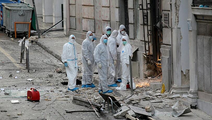 Ermittler untersuchen den Anschlagsort vor dem Büro des griechischen Industrieverbands in Athen. Ermittler untersuchen den Anschlagsort vor dem Büro des griechischen Industrieverbands in Athen.