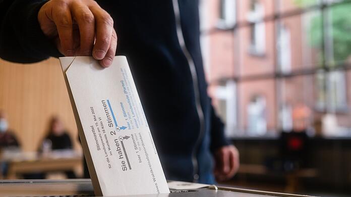 Ein Mann wirft seinen Stimmzettel in die Wahlurne.