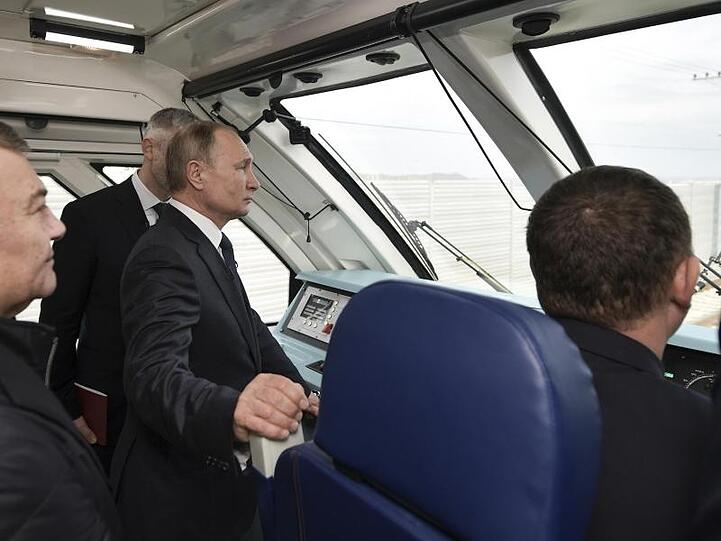 Im Führerstand: Wladimir Putin fährt per Zug über die neue 19 Kilometer lange Brücke, die die Krim mit dem russischen Festland verbindet.