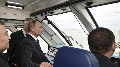 Im Führerstand: Wladimir Putin fährt per Zug über die neue 19 Kilometer lange Brücke, die die Krim mit dem russischen Festland verbindet.