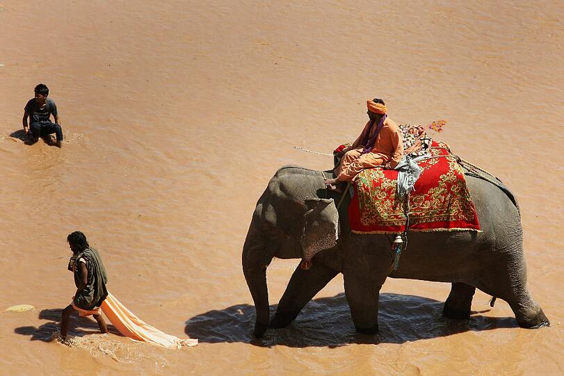 Ein indischer Mahout (Elefanten-Meister) reitet auf einem Elefanten durch den Tawi-Fluss in Jammut, Indien. Dort ist heute der letzte Tag des Navratra Hindu Festivals.