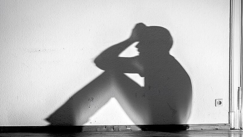 Die Schatten eines hilfsbedürftigen, psychisch kranken Menschen an einer Wand (Symbolbild). Die Schatten eines hilfsbedürftigen, psychisch kranken Menschen an einer Wand (Symbolbild).