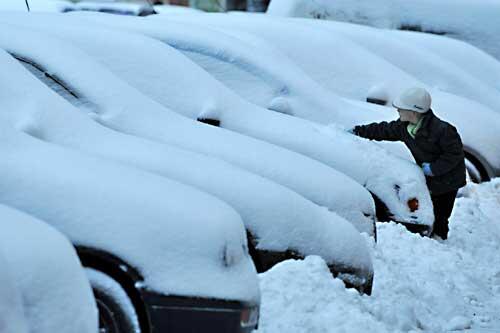 Dieser Bub versucht das Auto von den Schneemassen zu befreien