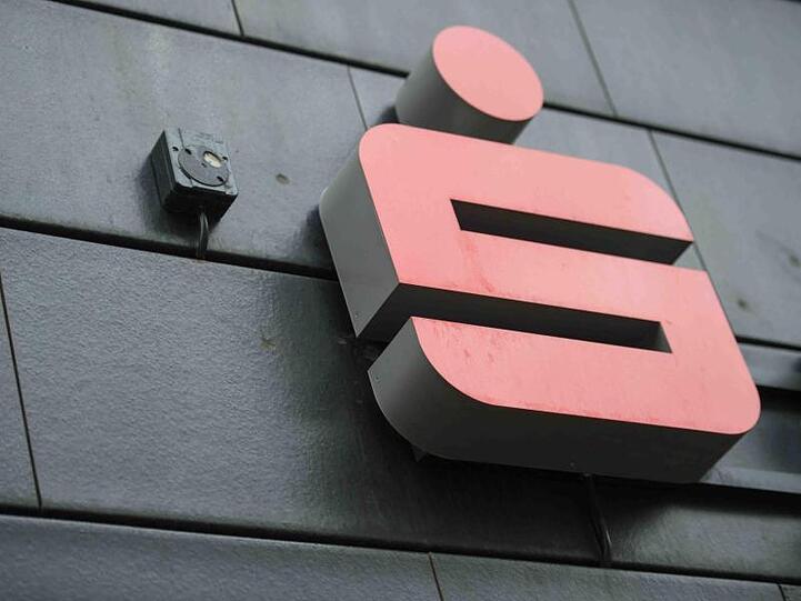 Ein Logo der Sparkasse hängt an einer Filiale. Foto: Arne Bänsch/Archivbild