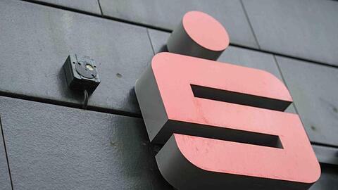 Ein Logo der Sparkasse hängt an einer Filiale. Foto: Arne Bänsch/Archivbild