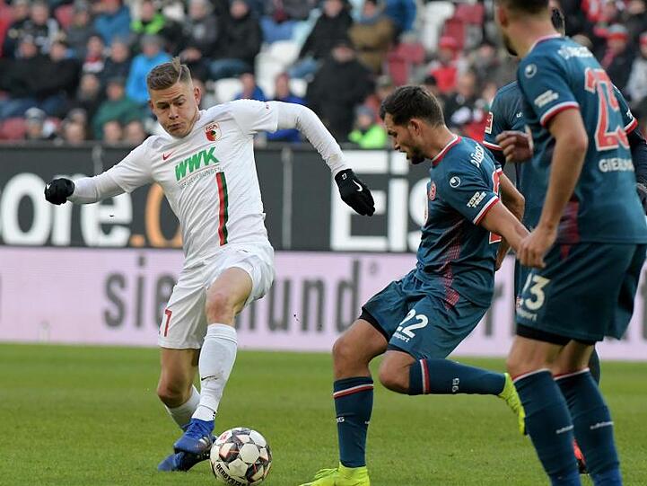 Augsburgs Alfred Finnbogason und Kevin Stöger von Düsseldorf (l-r.) im Zweikampf um den Ball. Foto: Stefan Puchner