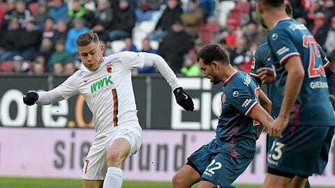Augsburgs Alfred Finnbogason und Kevin Stöger von Düsseldorf (l-r.) im Zweikampf um den Ball. Foto: Stefan Puchner