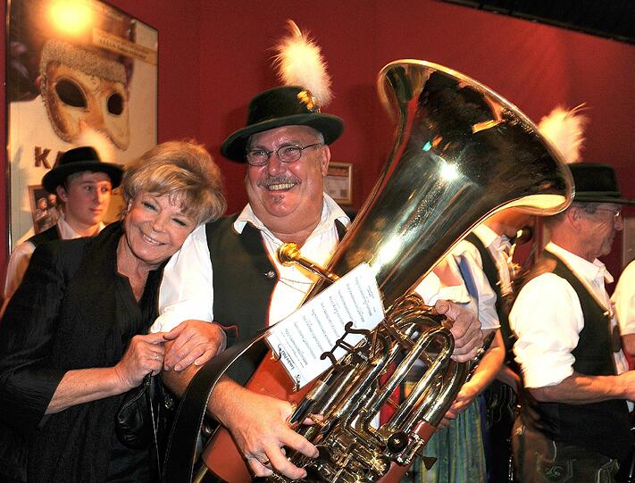Die Schauspielerin Grit Boettcher posiert mit Karl Schabmair, einem Musiker der Blaskapelle Egmating, bei der Premiere "Im Weissen Rössl" im Deutschen Theater.