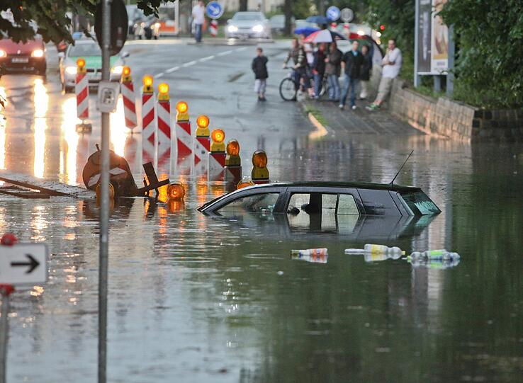 Ein Auto steht am Sonntagabend (10.07.2011) nach einem Unwetter auf einer überfluteten Straße in Nürnberg (Mittelfranken). Gewitter in Bayern hat am Sonntagabend zu hunderten Notrufen bei Polizei und Feuerwehr geführt.