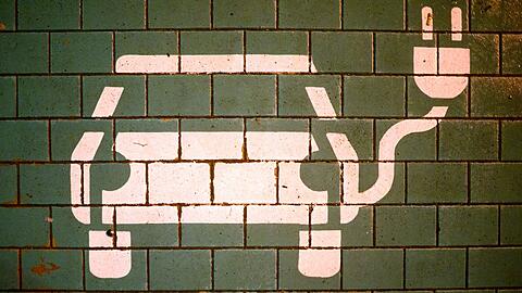 Ein Symbol markiert einen Parkplatz mit einer öffentlichen Ladesäule für Elektroautos.