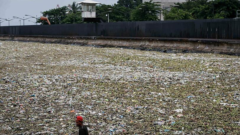 Treibmüll: In Manila watet ein Mann durch ein vermülltes Hafenbecken. Die philippinische Hauptstadt hat noch immer mit den Folgen von Taifun Nida zu kämpfen. Foto: Mark R. Cristino Treibmüll: In Manila watet ein Mann durch ein vermülltes Hafenbecken. Die philippinische Hauptstadt hat noch immer mit den Folgen von Taifun Nida zu kämpfen. Foto: Mark R. Cristino