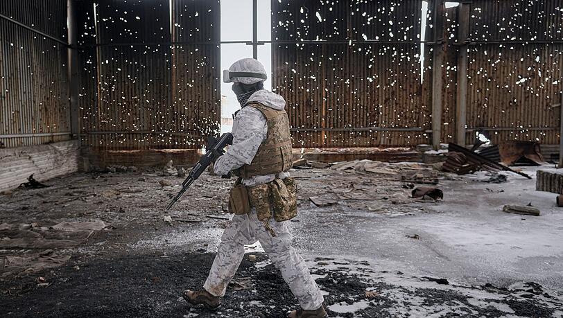 Ein ukrainischer Soldat geht durch eine zerstörte Lagerhalle an der Frontlinie in der Region Donezk.