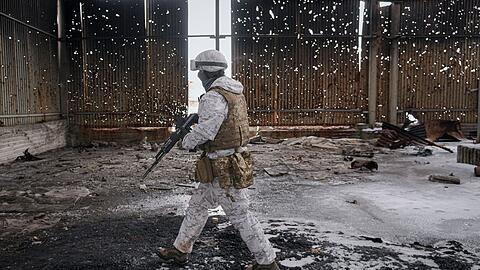 Ein ukrainischer Soldat geht durch eine zerstörte Lagerhalle an der Frontlinie in der Region Donezk.