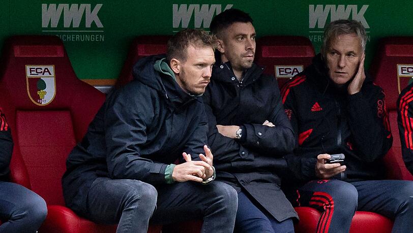 Münchens Trainer Julian Nagelsmann (l) sitzt auf der Trainerbank.